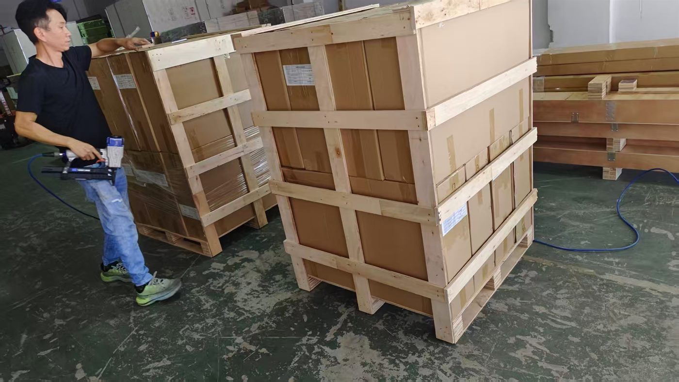 Worker sealing wooden crates for shipment
